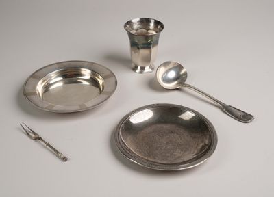 un plateau en argent avec des cuillères, une coupe en argent et une cuillère