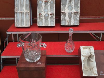 trois vases et un verre posés sur une table rouge