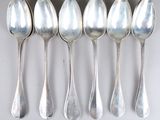 six silver spoons lined up in a row on a white surface