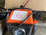 an orange and black machine sitting on top of a table next to a cardboard box