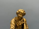 figurine en bronze représentant un garçon tenant un oiseau