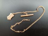 a gold chain with a lighter on it on a table