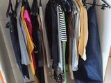 many clothes hanging on a rack in a closet