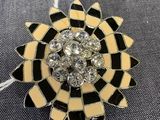 un gros plan sur une broche en forme de fleur en noir et blanc