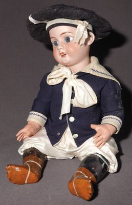 une petite poupée assise par terre