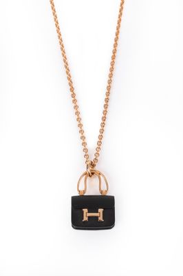a gold chain with a black purse on it