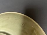 a green bowl with a piece of food in it