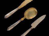three pieces of silverware including a knife, spoon, and spoon rest