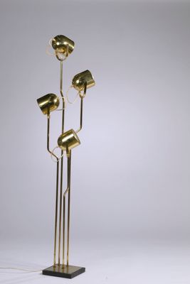 a brass floor lamp with five lamps on a black base