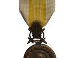 l'image d'une médaille ornée d'un ruban doré sur fond blanc