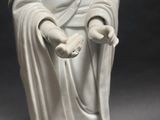 a white statue of a woman holding a flower in her hands