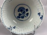a blue and white bowl on a stand on a white surface