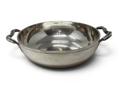 a large metal bowl with handles on a white surface