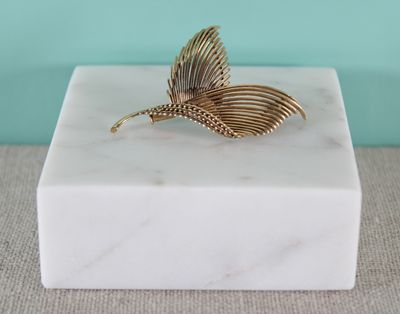 un coffret en marbre blanc surmonté d'une feuille d'or