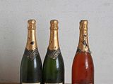 trois bouteilles de champagne posées sur une table l'une à côté de l'autre