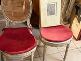 une paire de chaises avec des coussins rouges et un cadre photo fixé à leur dossier