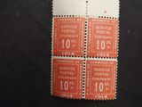 four different postage stamps on a black surface