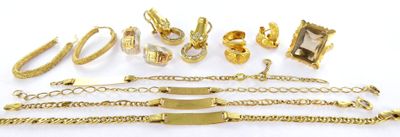 a lot of gold jewelry on a white surface