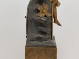 a bronze statue of a man sitting on a chair