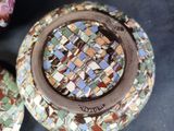 two plates with mosaic designs on them sitting on a table