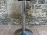 a table with a metal base on a brick floor