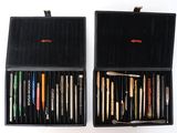 deux boîtes noires contenant des stylos et des crayons