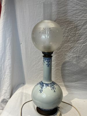 une lampe posée sur une table devant un rideau