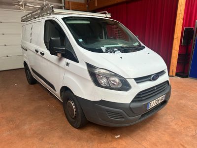 La camionnette blanche est garée dans le garage, devant un rideau rouge.