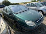 a green car parked in a parking lot with other cars