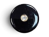 une image représentant un bouton noir orné d'un diamant