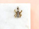 a close up of a spider pendant on a marble surface