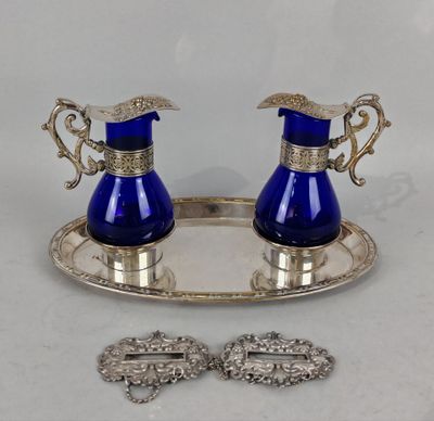 une paire de vases en verre bleu posés sur un plateau en argent, accompagnés d'une paire de broches