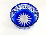 a blue glass bowl with a white flower in it