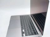 a silver laptop with a black keyboard on a white surface