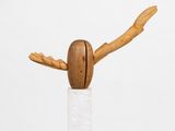 sculpture of a bird made of wood on a white pedestal