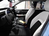 the interior of a car with black and white seats and a steering wheel