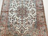 an antique persian rug with a floral design on a white ground