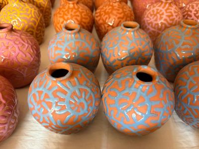 de nombreux vases de différentes couleurs posés sur une table