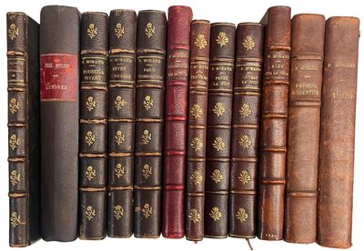 plusieurs vieux livres sont alignés sur une surface blanche