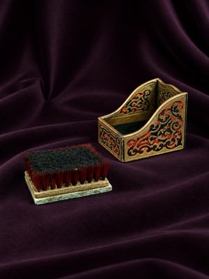 an image of a brush and brush holder sitting on a purple cloth