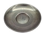 a silver plate with a design on it on a white background