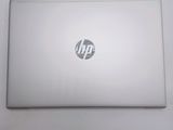 the hp laptop is sitting on a white surface with a small sticker on it