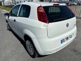 une petite voiture blanche garée sur le bord de la route