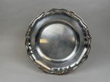 a silver plate with a decorative design on the rim