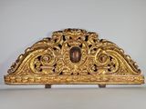une étagère en or richement décorée, surmontée d'une horloge