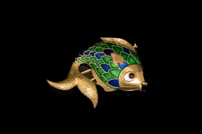 une broche en forme de poisson vert et bleu sur fond noir