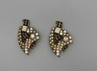 Paire de clips en métal doré patiné et strass noir et blanc.