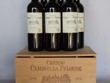 four bottles of wine sit in a wooden box on a table