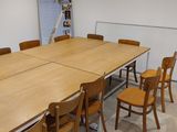 tables and chairs in a room with a large poster on the wall
