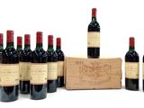 six bouteilles de vin rouge sont alignées à côté d'une caisse en bois